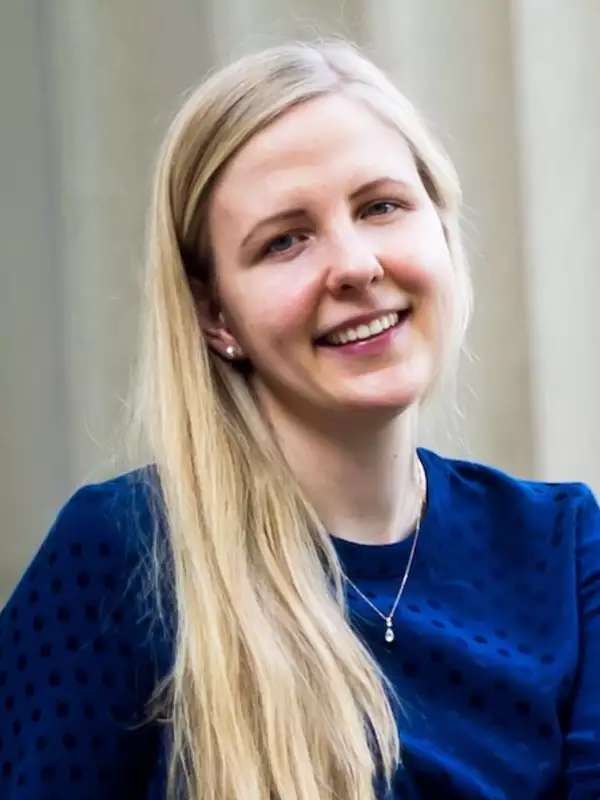 Photo of Prof. Alisa Knizel wearing a blue hair and showing her long blond hair.